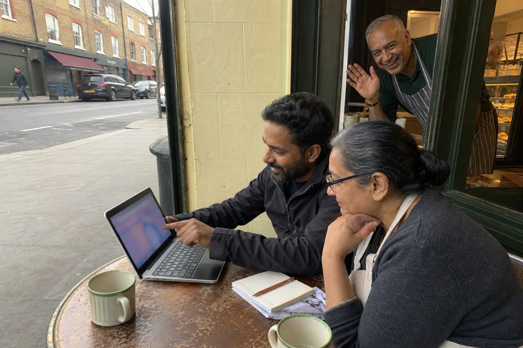 A local shop owner and digital consultant reviewing a new website together